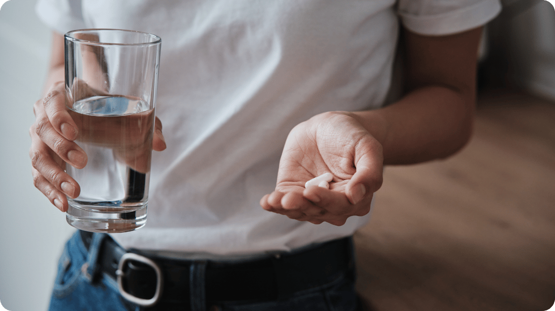 Image of woman taking pills with water
